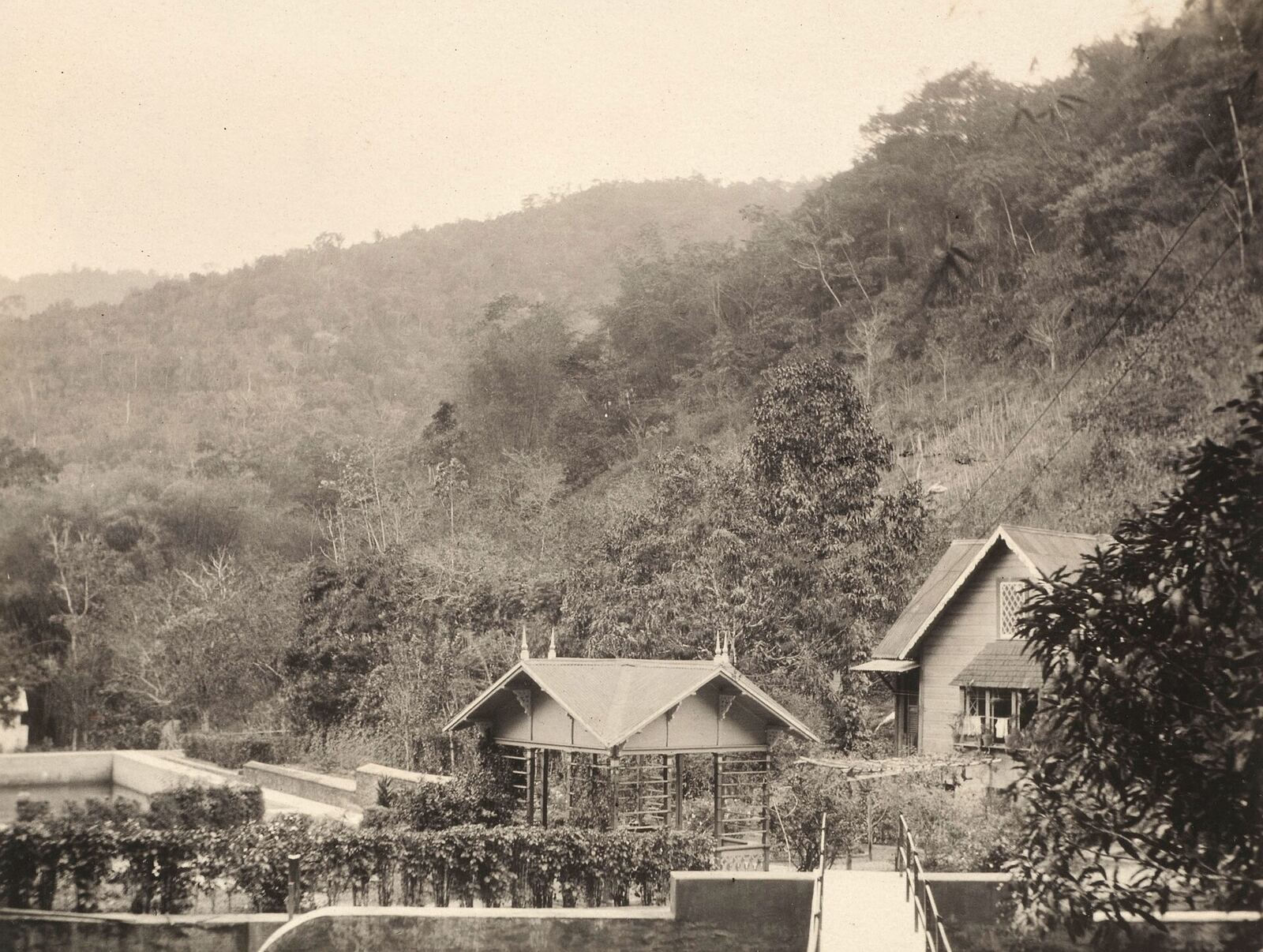 Archive photograph of the Maraval reservoir, Port of Spain, with a wooden pavilion and forested hillside